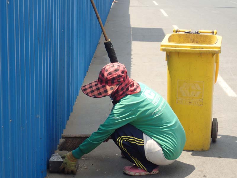 暑い中、女性が 道路清掃を しています。 大きな通りには あまりゴミ落ちて いないです。